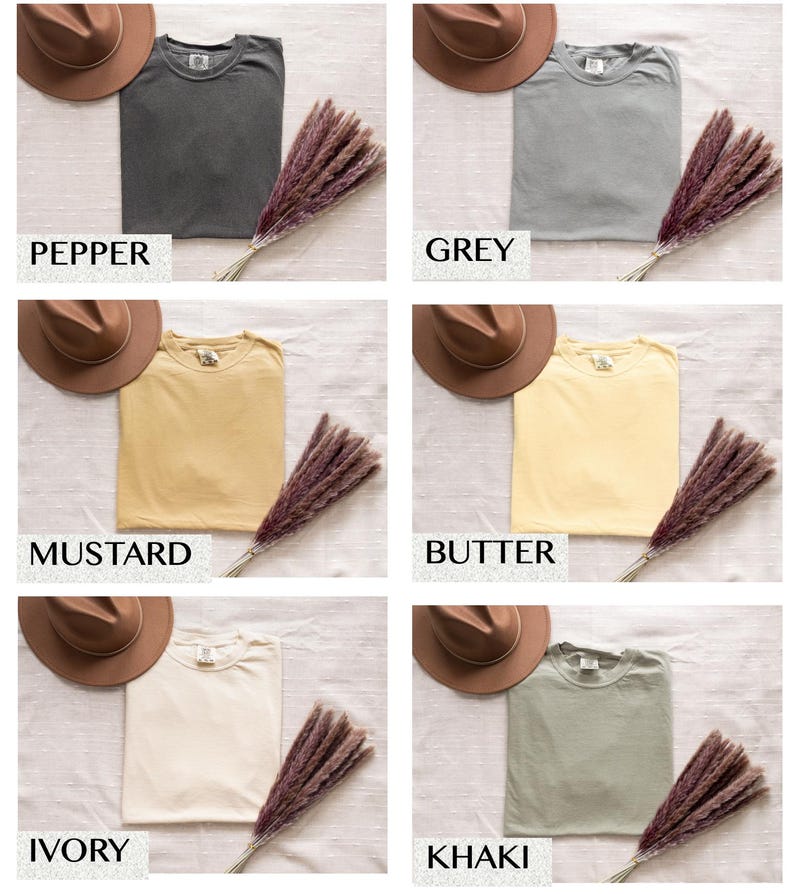 Puede incluir: Colecci&oacute;n de seis camisetas plegadas en varios colores: pimienta, gris, mostaza, mantequilla, marfil y caqui. Cada camiseta se combina con un sombrero marr&oacute;n y un manojo de hierba seca de color p&uacute;rpura-marr&oacute;n. El color de cada camiseta est&aacute; etiquetado.