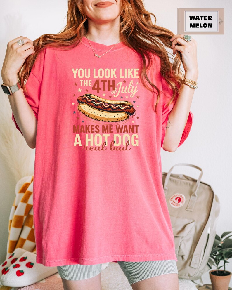 May include: Pink t-shirt with a graphic of a hot dog and the text "You look like the 4th of July makes me want a hot dog real bad".
