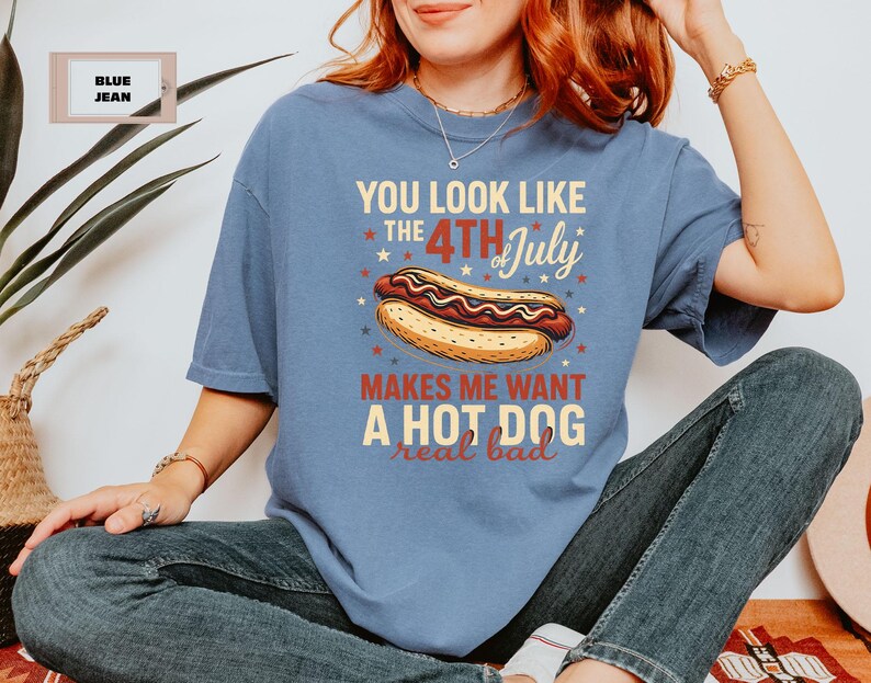 May include: A blue t-shirt with the text "You look like the 4th of July makes me want a hot dog real bad" printed on it.