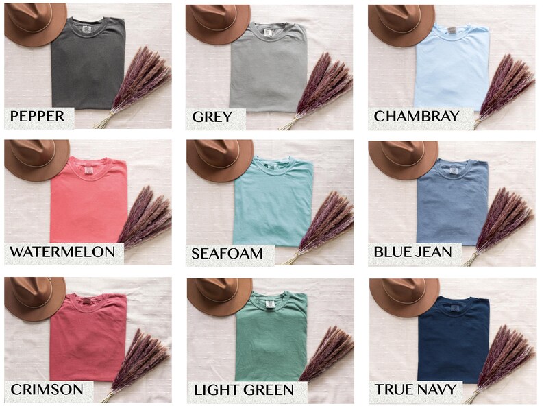 May include: Nine different colored t-shirts, including pepper, grey, chambray, watermelon, seafoam, blue jean, crimson, light green, and true navy. Each shirt is folded and displayed with a brown hat and a bundle of dried flowers.