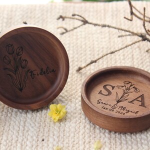 Puede incluir: Dos platos redondos de madera marr&oacute;n oscuro con dise&ntilde;os grabados. Uno presenta una ilustraci&oacute;n de tulipanes y el nombre Fidelia. El otro muestra las iniciales S y A, los nombres Saara & Abigail y la fecha 08 de enero de 2024.