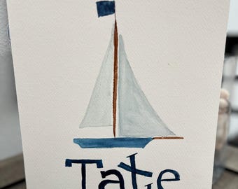 May include: A watercolor painting of a sailboat with a blue hull and white sails. The sailboat has a small blue flag on top of the mast. The name "Tate" is written in blue below the sailboat.
