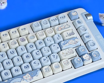 May include: A white keyboard with blue keys featuring cute cartoon bear illustrations. The keys are labeled with letters, numbers, and function keys. The keyboard has a light blue and white color scheme.