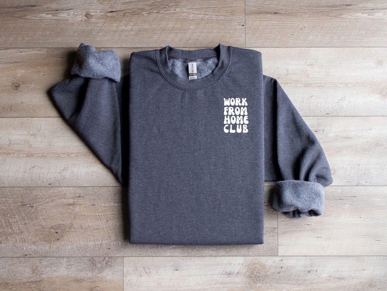 K&ouml;nnte beinhalten: Ein dunkelgrauer Pullover mit dem Text "WORK FROM HOME CLUB" in Wei&szlig; auf der Vorderseite.