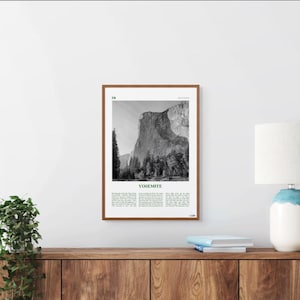May include: A black and white photograph of El Capitan in Yosemite National Park, California. The image is framed in a brown wood frame. The text "Yosemite" is printed in green below the image.