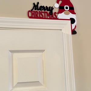 Angled perspective of the gnome door corner piece placed on the upper corner of a white door frame.