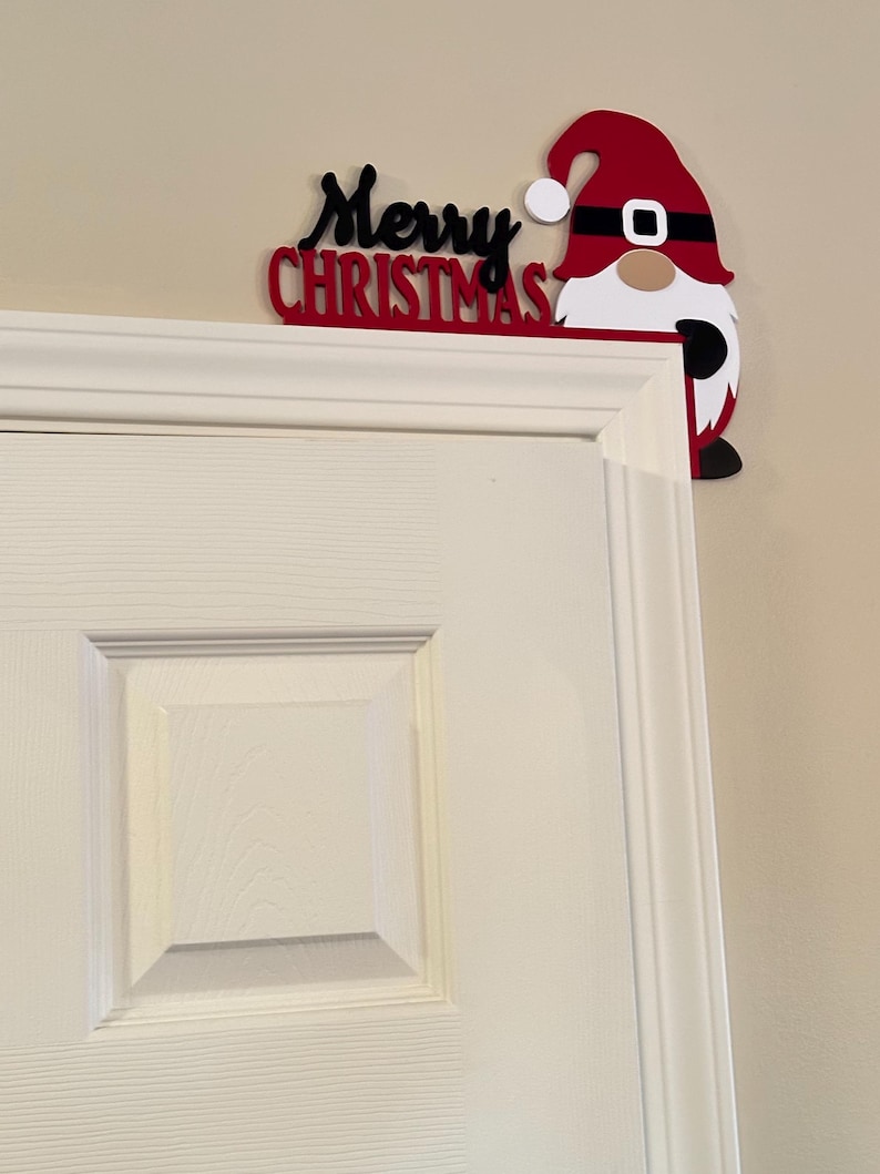 Angled perspective of the gnome door corner piece placed on the upper corner of a white door frame.