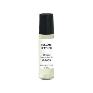 May include: A clear glass roll-on bottle with a black cap. The label reads "TUSCAN LEATHER" and "Unisex Fragrance Body Oil." The bottle contains a light-colored liquid and is labeled "O-T403" and "QUEEN2KEEPUP 1/3 oz."