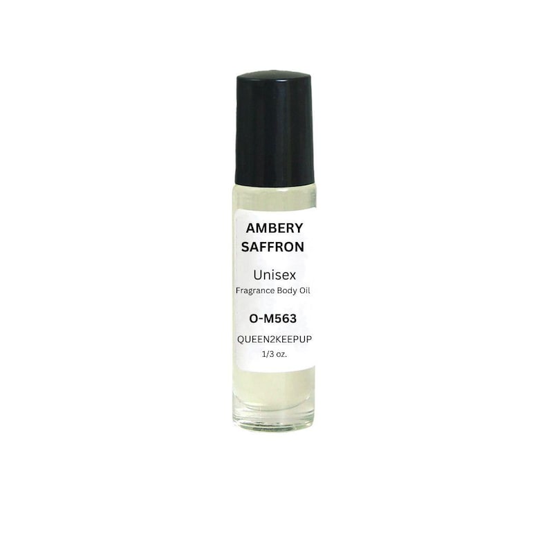 Puede incluir: Un frasco roll-on de vidrio transparente con tapa negra. La etiqueta dice "AMBERY SAFFRON Unisex Fragrance Body Oil O-M563 QUEEN2KEEPUP 1/3 oz."