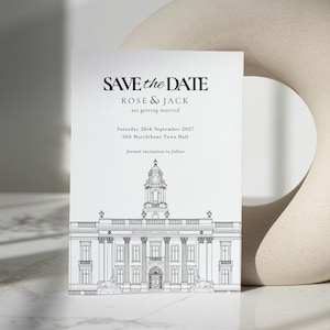 Puede incluir: Una tarjeta blanca de Save the Date con texto negro, con los nombres Rose & Jack y detalles de la boda. La tarjeta incluye una ilustración arquitectónica detallada de Old Marylebone Town Hall. La tarjeta mide 12,7 x 17,8 cm. Un jarrón beige abstracto está en el fondo.