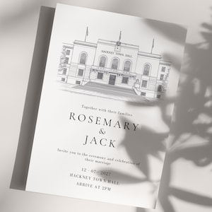 May include: A white wedding invitation featuring a detailed black and white illustration of Hackney Town Hall. The card includes the names "Rosemary & Jack", event details, and the text "DIY in a Sec". The card measures 12.7 x 17.8 cm.