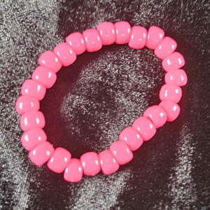 May include: A pink beaded bracelet with round beads.