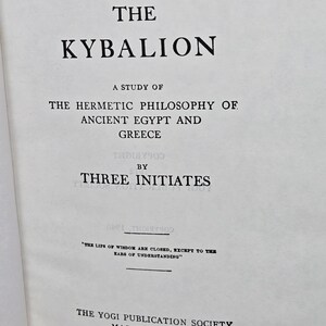 Puede incluir: P&aacute;gina de libro abierta con el t&iacute;tulo "THE KYBALION" en negrita negra. El texto de abajo dice "A STUDY OF THE HERMETIC PHILOSOPHY OF ANCIENT EGYPT AND GREECE" y "BY THREE INITIATES". La parte inferior de la p&aacute;gina dice "THE YOGI PUBLICATION SOCIETY MASONIC TEMPLE CHICAGO, ILL."