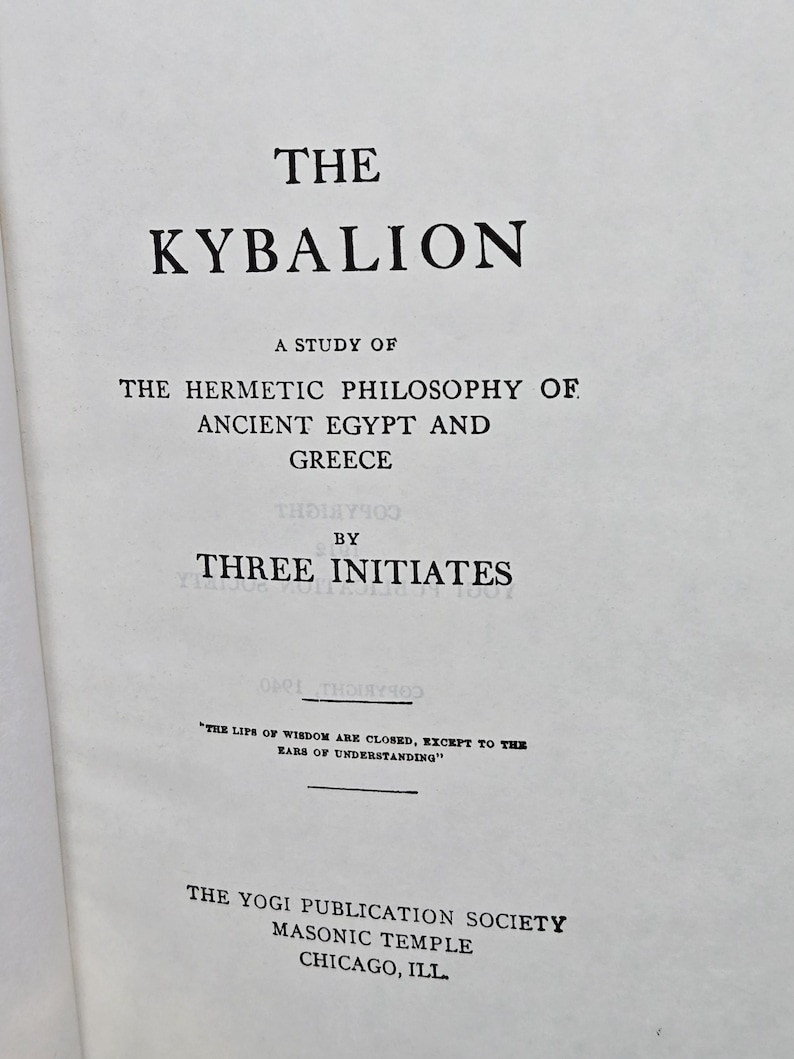 Puede incluir: P&aacute;gina de libro abierta con el t&iacute;tulo "THE KYBALION" en negrita negra. El texto de abajo dice "A STUDY OF THE HERMETIC PHILOSOPHY OF ANCIENT EGYPT AND GREECE" y "BY THREE INITIATES". La parte inferior de la p&aacute;gina dice "THE YOGI PUBLICATION SOCIETY MASONIC TEMPLE CHICAGO, ILL."