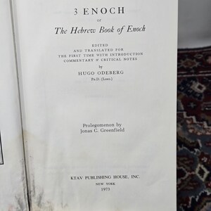May include: Open book with the title "3 Enoch or The Hebrew Book of Enoch." The text is edited and translated by Hugo Odeberg, Ph.D. (Lond.). Published by KTAV Publishing House, Inc., New York, in 1973. The book is open to a page with text.