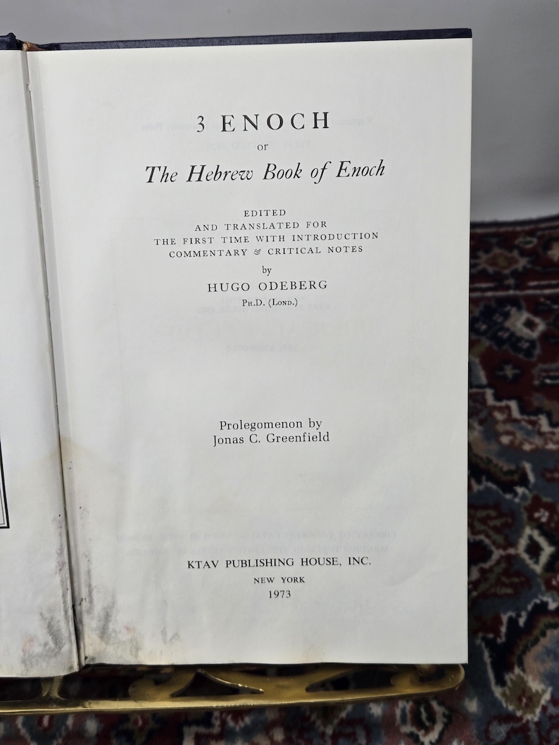 May include: Open book with the title "3 Enoch or The Hebrew Book of Enoch." The text is edited and translated by Hugo Odeberg, Ph.D. (Lond.). Published by KTAV Publishing House, Inc., New York, in 1973. The book is open to a page with text.