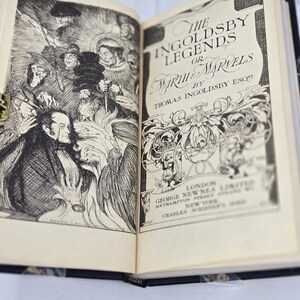 May include: An open book with a black and white illustration on the left page and the title "The Ingoldsby Legends or Mirth & Marvels by Thomas Ingoldsby Esq" on the right page.