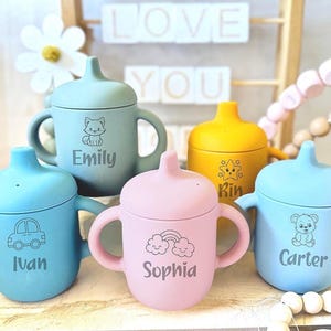 Pode incluir: Quatro copos de silicone coloridos com al&ccedil;as e tampas. Cada copo tem um design e um nome diferente: Emily, Ivan, Sophia e Carter.