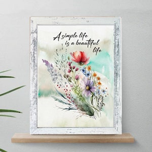 May include: A white framed print with a watercolor painting of a bouquet of flowers in shades of pink, purple, red, and yellow. The text "A simple life is a beautiful life" is printed in black on the print.