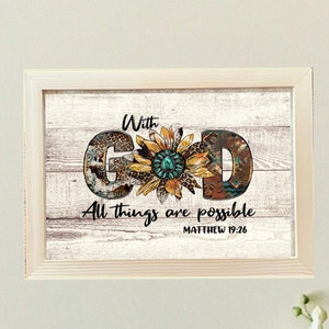 May include: A framed print with a white wood background featuring the word "GOD" in brown letters with a sunflower design in the center. The text "With God All things are possible Matthew 19:26" is written below the sunflower.