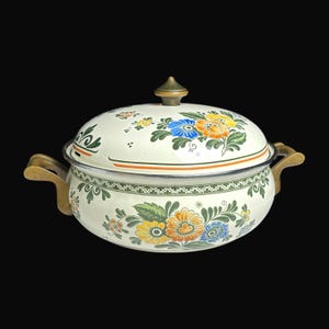 Könnte beinhalten: Cremefarbene Emaille-Auflaufform mit Deckel, verziert mit bunten Blumenmustern in Blau, Orange und Gelb. Sie hat Messinggriffe und einen Messingknopf auf dem Deckel. Die Schüssel hat einen dekorativen grünen Rand. Ca. 25 cm Durchmesser.