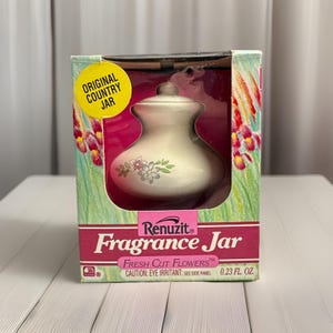 May include: A vintage Renuzit Fragrance Jar in its original box. The jar is off-white with a floral design and a lid. The box features the text "Fresh Cut Flowers" and "Original Country Jar."
