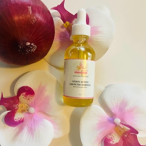 May include: A clear glass bottle of L'Orchidée Onion Active Growth Complex with a white dropper, set against a backdrop of white and pink orchid blossoms and a red onion. The label reads "Onion Active Growth Complex".
