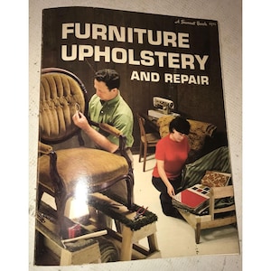 May include: A vintage book titled "Furniture Upholstery and Repair" with a sunset book logo. The cover features a man and woman working on furniture upholstery. The man is using a tool to attach fabric to a chair, while the woman is looking at fabric swatches.