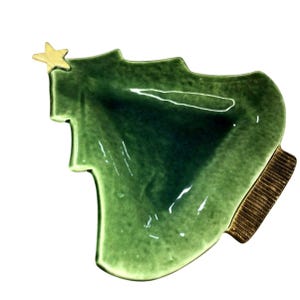 May include: A green ceramic Christmas tree-shaped dish with a gold star on top. The dish has a textured surface and a brown, ribbed base. The tree-shaped dish is perfect for serving holiday treats.