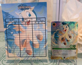 May include: A Disney Lorcana score sheet featuring a light-colored Pegasus illustration and a matching holographic Pegasus trading card. The score sheet includes columns for three rounds of play, while the card displays the character name Pegasus, the subtitle Gift for Hercules, and game statistics.