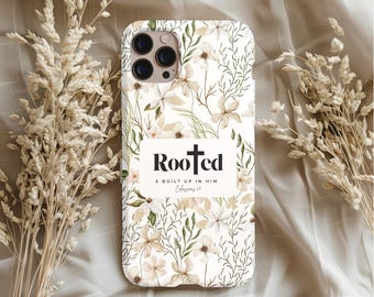 May include: White iPhone case with a floral pattern and a white rectangle with the text "Rooted & built up in him Colossians 2:7".