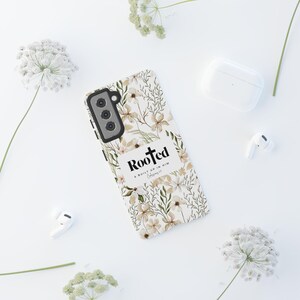 May include: A white phone case with a floral pattern and the text "Rooted & Built Up In Him - Colossians 2:7".