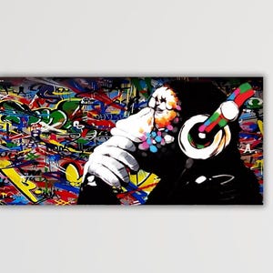 Peut inclure: Impression sur toile de style pop art représentant un chimpanzé portant un casque. Le singe est en silhouette noire sur un fond de graffiti coloré. Le casque a un design arc-en-ciel, ajoutant une touche de couleur à l'œuvre.