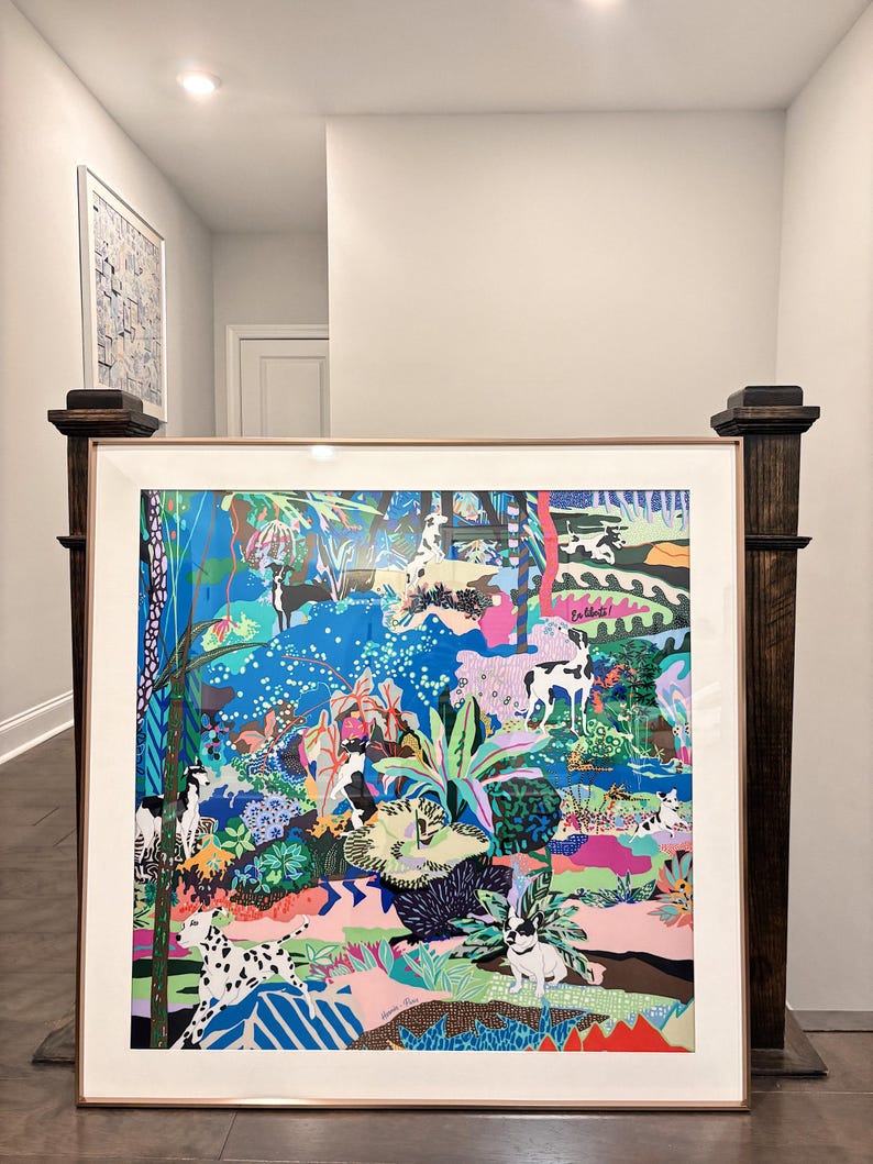 Puede incluir: Una gran impresi&oacute;n art&iacute;stica enmarcada que presenta una escena de selva vibrante y colorida llena de varias razas de perros, plantas tropicales exuberantes y patrones abstractos. La obra incluye azules, rosas y verdes brillantes, con el texto "En route!" visible.