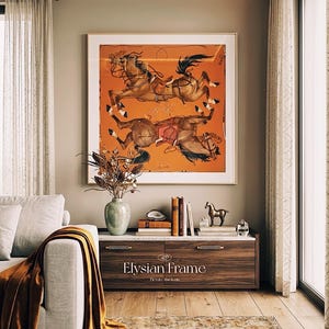 Puede incluir: Una pieza de arte mural cuadrada enmarcada que presenta un fondo naranja con dos caballos marrones con arn&eacute;s, exhibida sobre una mesa consola de madera con el texto Elysian Frame Elevate the Icon impreso en el panel del caj&oacute;n frontal.