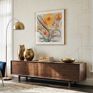 Puede incluir: Un mueble multimedia de madera largo y rectangular con cuatro puertas de armario, coronado con dos jarrones met&aacute;licos dorados, una pila de tres libros y un cuenco dorado poco profundo, situado bajo una l&aacute;mina bot&aacute;nica con flores amarillas y naranjas.