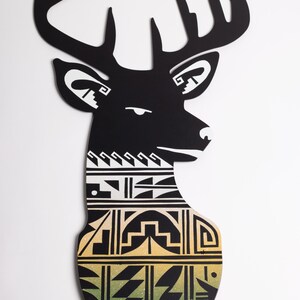 May include: Black deer head silhouette wall decor with a geometric pattern in white, black, and green. The pattern is reminiscent of Native American art. The deer head has gold hooks for hanging keys or other items.
