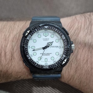 May include: A black Casio Quartz watch with a white face, featuring a black bezel with white markings. The watch displays the day as FRI 17 and is water-resistant to 20 bar.