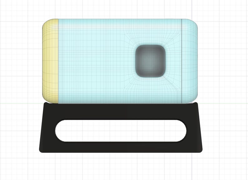 May include: A light blue and yellow rectangular box with a small square window in the center, sitting on a black stand with a cutout in the front.