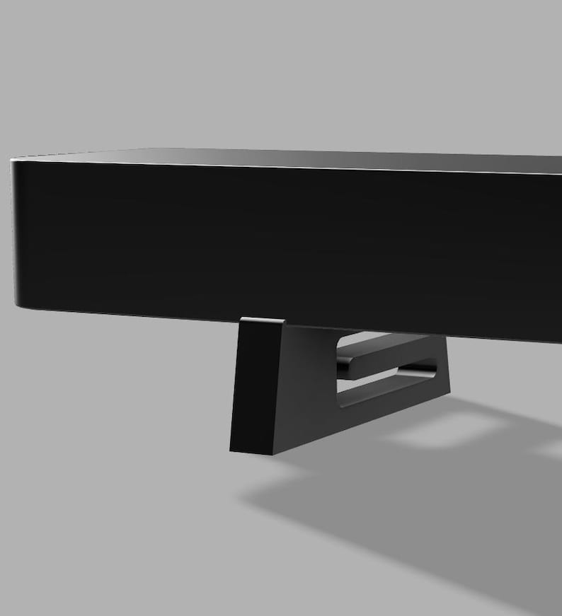 Pu&ograve; includere: Una mensola nera e rettangolare dal design minimalista. La mensola &egrave; sostenuta da un supporto angolare nero. Il supporto ha un design ritagliato. La mensola e il supporto sono su sfondo grigio.