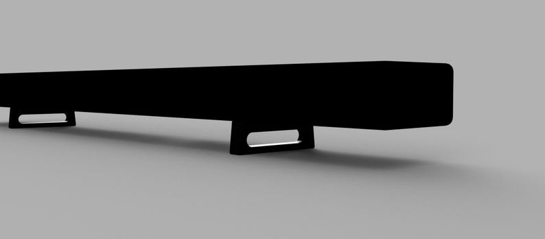 May include: A black rectangular soundbar with two small rectangular feet on each end.