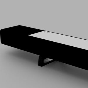 May include: A black soundbar with a white label that says "SONY" on it. The soundbar has a black metal stand.
