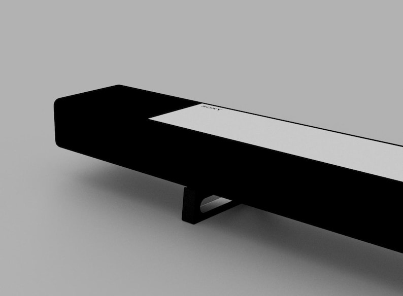 May include: A black soundbar with a white label that says "SONY" on it. The soundbar has a black metal stand.