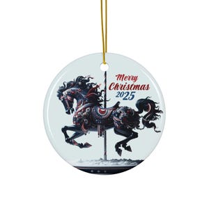 May include: A round Christmas ornament featuring a carousel horse design in red, white, and blue. The horse is adorned with intricate details and stands on a pole. The ornament has the text "Merry Christmas 2025". A gold string is attached for hanging.