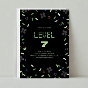 May include: A black and green birthday invitation with a pixelated green and white "Level 7" graphic. The invitation is decorated with confetti in various colors and shapes, including squares, circles, and triangles. The text reads "Tom has reached Level 7. Join us for a day full of fun and mischief. Saturday, November 30th at 2:30 p.m. The Sawyer Residence."