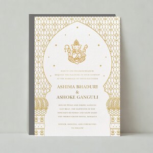 May include: Gold wedding invitation with an ornate design featuring a Hindu deity. The invitation announces the marriage of Ashima Bhaduri and Ashoke Ganguli on Saturday, the eleventh of May, nineteen hundred and sixty eight at the Oberoi Grand Hotel, Kolkata. Dinner, dancing, and ceremonies to follow.