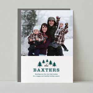 Puede incluir: Tarjeta navideña con una foto familiar en un entorno nevado. La tarjeta incluye el texto "the BAXTERS" y un mensaje navideño. La familia viste ropa de invierno, incluyendo abrigos, gorros y guantes.