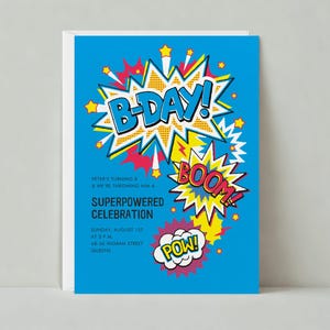 以下が含まれることがあります： 青い誕生日の招待状で、漫画スタイルのグラフィックです。「B-DAY！」の文字は白と黄色のバーストです。他のテキストには「BOOM！」と「POW！」、イベントの詳細が含まれています。
