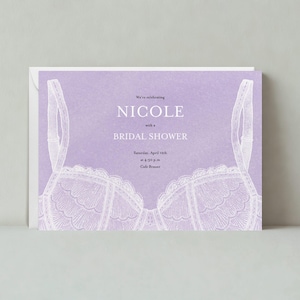 May include: Purple bridal shower invitation featuring a white lace bra design. The invitation reads "We're celebrating Nicole with a Bridal Shower" and includes the date and time of the event.