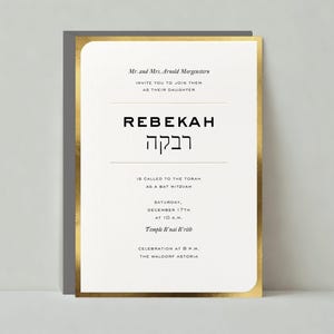 May include: A white invitation with a gold border announcing a Bat Mitzvah for Rebekah. The invitation includes the date, time, and location of the event. The Hebrew text translates to "Rebekah".